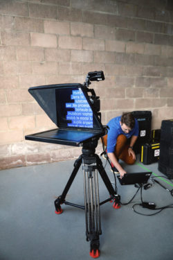 A camera tech edits the prompts on the iKan Teleprompter