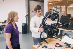 Rental house technician prepping camera gear for film production.