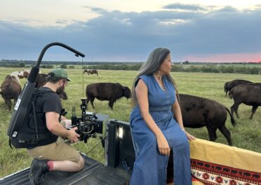 Film crew shooting documentary filmmaking behind the scenes with buffalo in remote location
